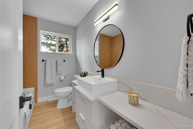 6526 S Elmwood St, Littleton, CO 80120 - bathroom featuring vanity, toilet, wood finished floors, and baseboards