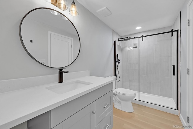 6526 S Elmwood St, Littleton, CO 80120 - bathroom with vanity, a stall shower, toilet, wood finished floors, and recessed lighting