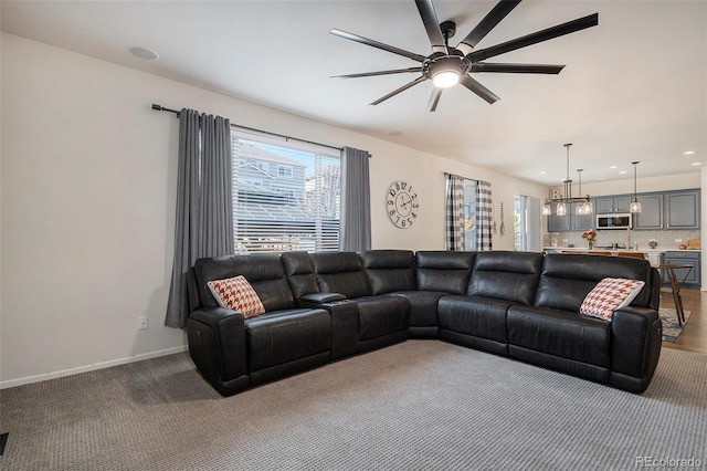 carpeted living room featuring ceiling fan