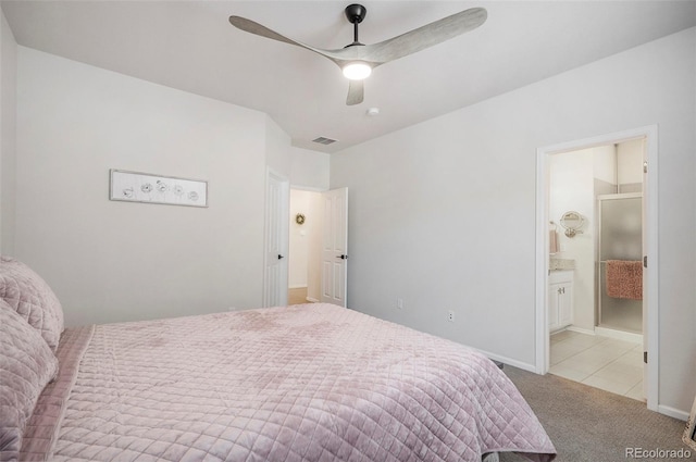 carpeted bedroom with ceiling fan and ensuite bath