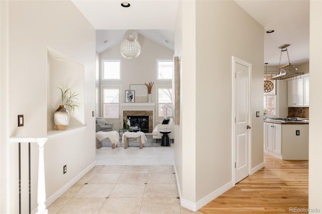 hallway featuring vaulted ceiling and light hardwood / wood-style flooring