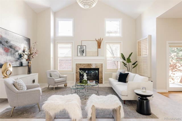 living room with a fireplace and high vaulted ceiling