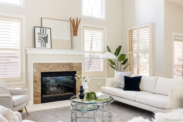 living room with a high end fireplace and a healthy amount of sunlight