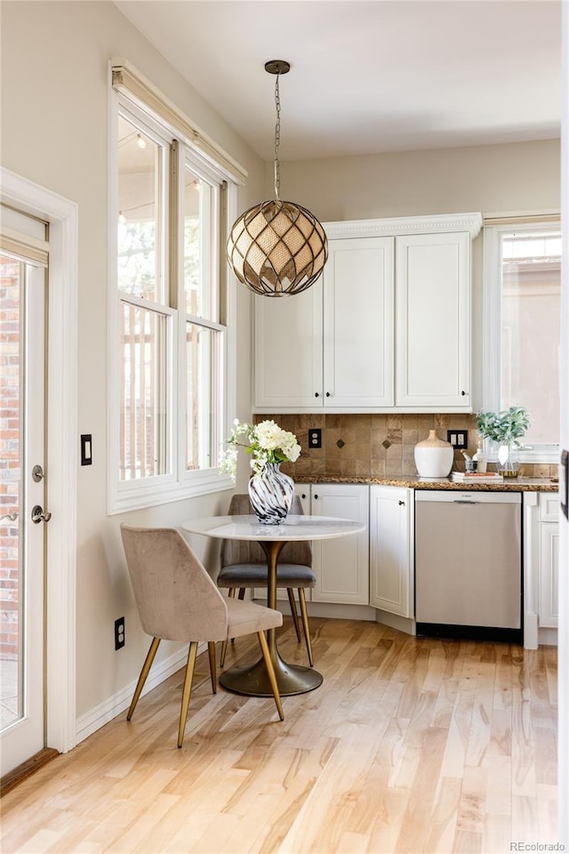 kitchen with light hardwood / wood-style floors, backsplash, dishwasher, pendant lighting, and white cabinets