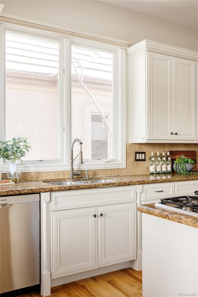 kitchen featuring sink, white cabinetry, dishwasher, and stone counters