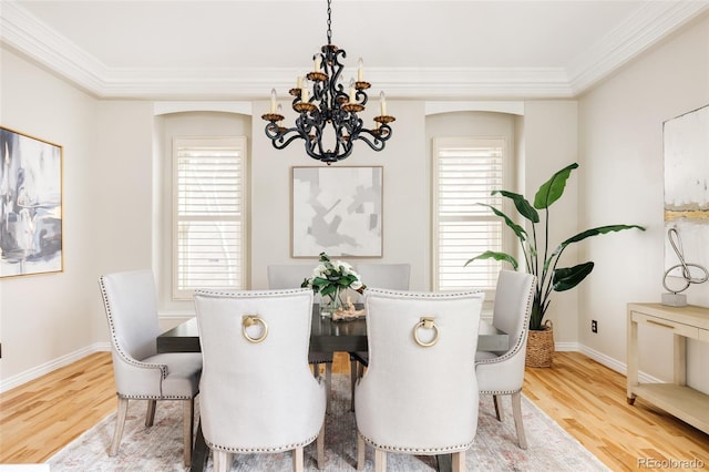 dining area with crown molding, wood-type flooring, and a notable chandelier