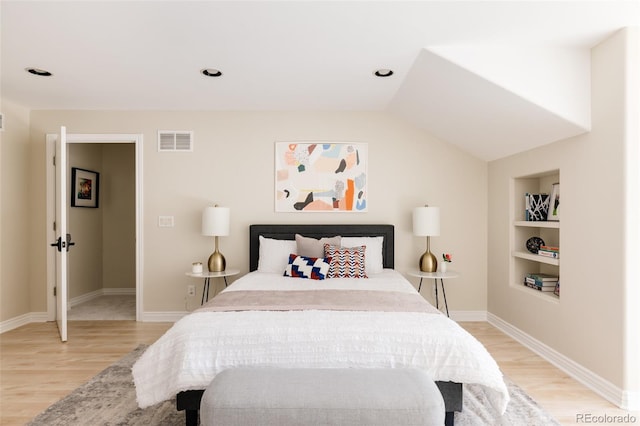 bedroom with light wood-type flooring and lofted ceiling