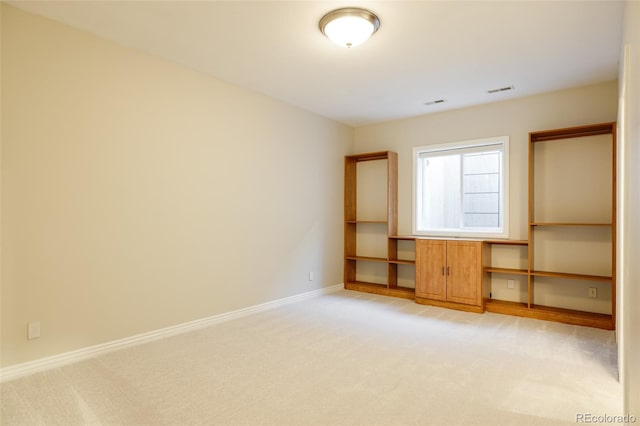 carpeted empty room with built in desk