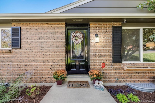 view of exterior entry with brick siding