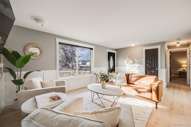 living room featuring a wainscoted wall and light wood-style flooring