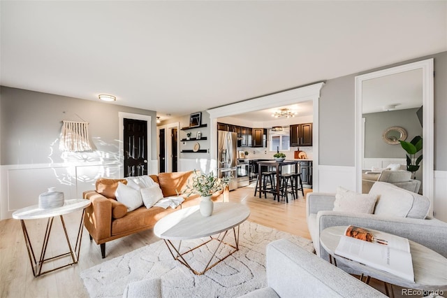 living room featuring light wood-type flooring and wainscoting