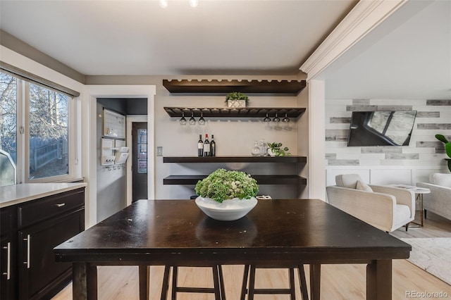 dining room with light wood-type flooring and a dry bar