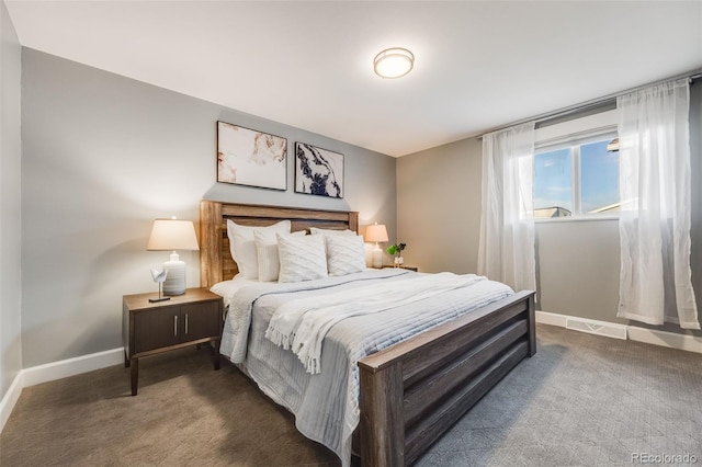 bedroom with baseboards and dark carpet