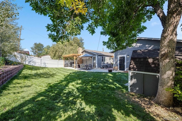 view of yard with a patio area, a fenced backyard, an outdoor structure, and a pergola