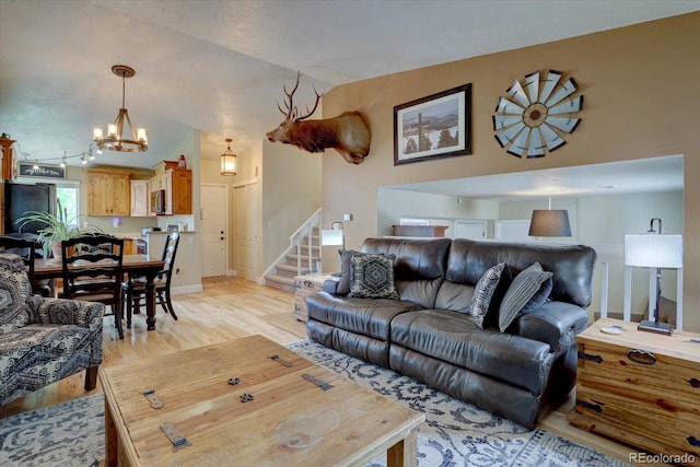 8745 W Ottawa Ave, Littleton, CO 80128 - living area featuring a chandelier, light wood-type flooring, stairway, and lofted ceiling