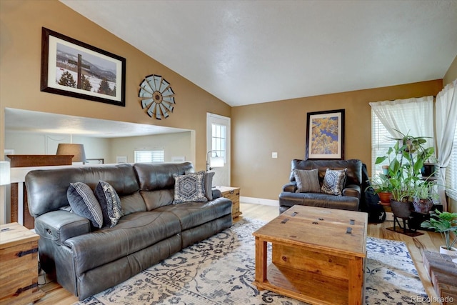 8745 W Ottawa Ave, Littleton, CO 80128 - living area with vaulted ceiling, light wood-style flooring, and baseboards