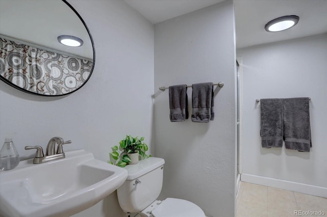 8745 W Ottawa Ave, Littleton, CO 80128 - full bath featuring a sink, tile patterned flooring, a stall shower, toilet, and baseboards
