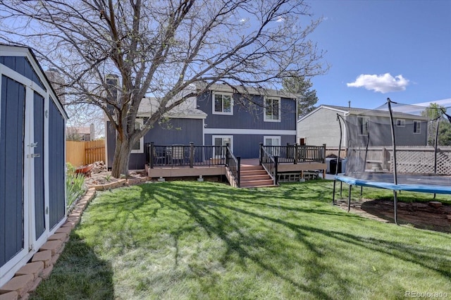 8745 W Ottawa Ave, Littleton, CO 80128 - back of property featuring a trampoline and a wooden deck