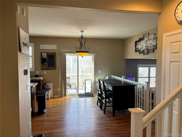 dining area featuring wood-type flooring and plenty of natural light