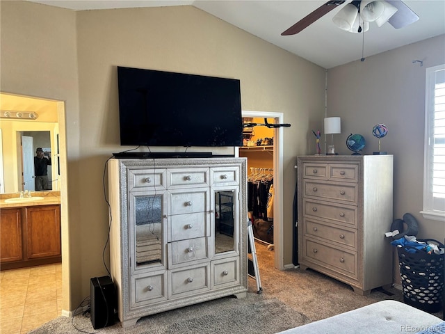 tiled bedroom with lofted ceiling, sink, a spacious closet, ceiling fan, and a closet