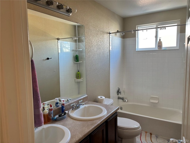 full bathroom featuring tiled shower / bath, vanity, and toilet