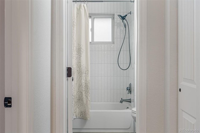 bathroom with toilet and shower / bath combo with shower curtain