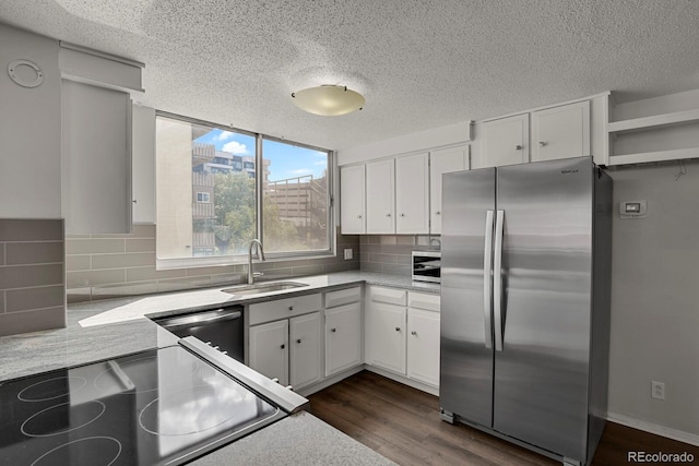 kitchen featuring freestanding refrigerator, white cabinets, a sink, range, and dishwashing machine