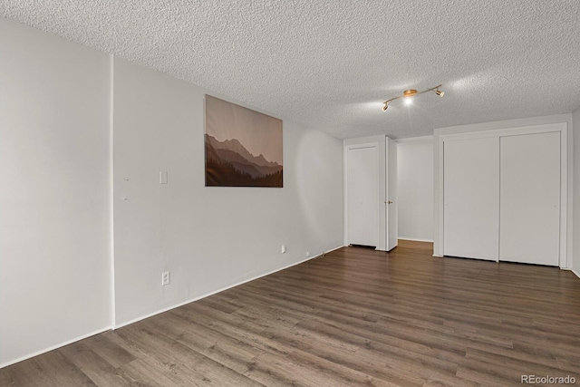 interior space with a textured ceiling and wood finished floors