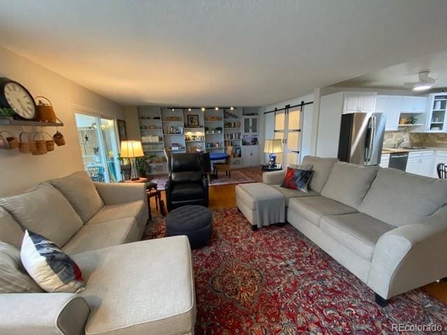 living room with a barn door and wood finished floors