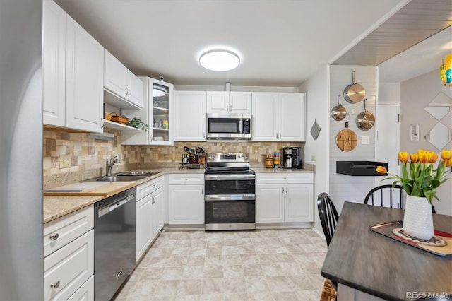 kitchen with white cabinetry, backsplash, appliances with stainless steel finishes, and a sink