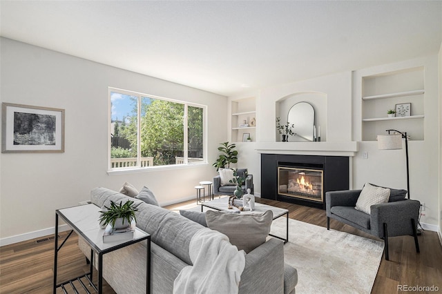 11868 W Progress Ave, Littleton, CO 80127 - living room featuring a glass covered fireplace, dark wood finished floors, and built in shelves