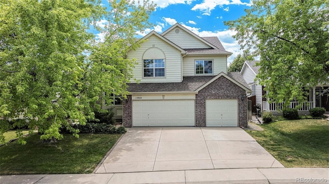 11868 W Progress Ave, Littleton, CO 80127 - view of front of property featuring a shingled roof, an attached garage, driveway, brick siding, and a front lawn