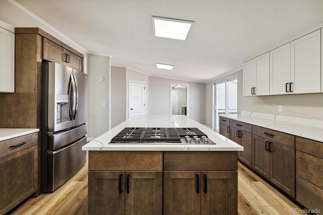 kitchen featuring white cabinets, appliances with stainless steel finishes, dark brown cabinets, and lofted ceiling