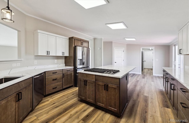 kitchen with pendant lighting, hardwood / wood-style flooring, white cabinetry, dark brown cabinetry, and stainless steel appliances