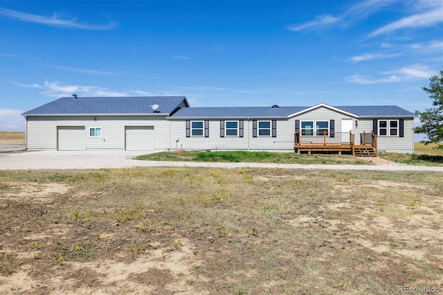 view of front facade featuring a garage, a deck, and a front lawn