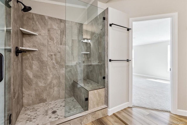 bathroom with wood-type flooring, an enclosed shower, and ornamental molding