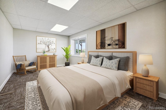 bedroom with a paneled ceiling and carpet