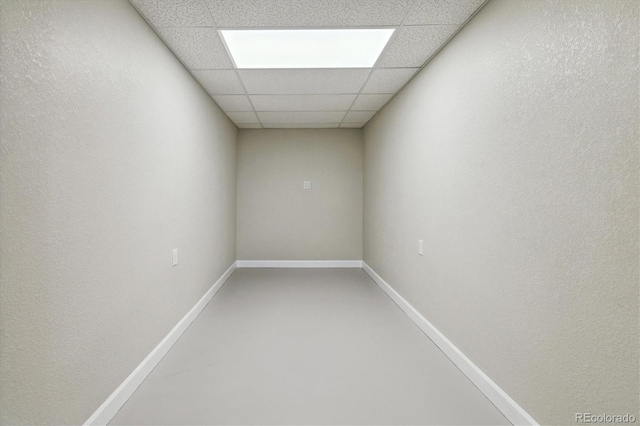 empty room featuring concrete flooring and a drop ceiling