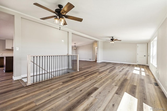 43343 E Arkansas Pl, Bennett, CO 80102 - unfurnished living room featuring ceiling fan, wood finished floors, ornamental molding, and baseboards