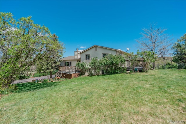 view of green lawn featuring a wooden deck