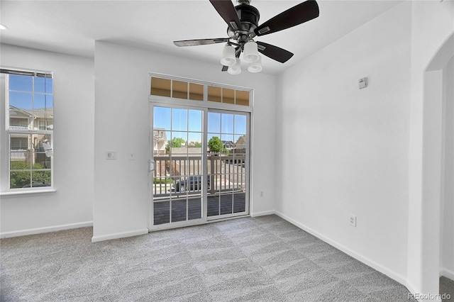 carpeted empty room featuring plenty of natural light and ceiling fan