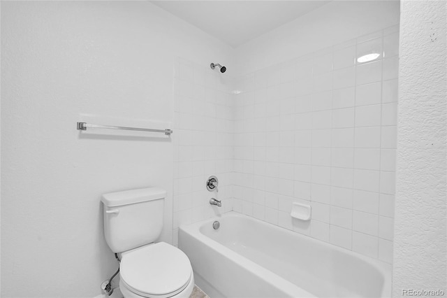 bathroom with tiled shower / bath and toilet