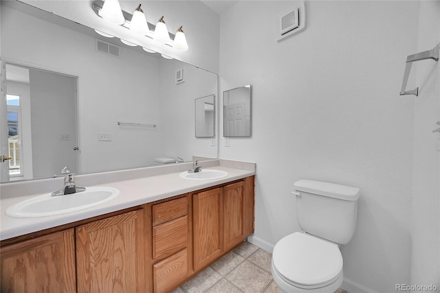 bathroom featuring dual vanity, toilet, and tile patterned flooring