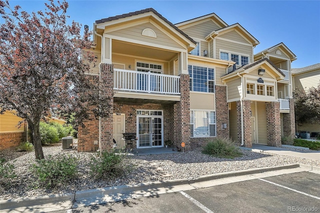 view of front of home featuring a balcony and central AC