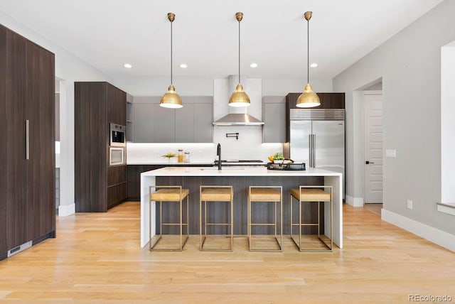 1500 S Elizabeth St, Denver, CO 80210 - kitchen with wall chimney exhaust hood, modern cabinets, tasteful backsplash, light countertops, and recessed lighting