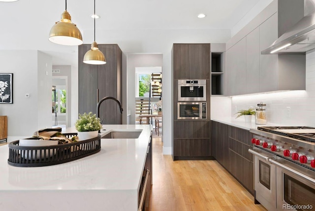 1500 S Elizabeth St, Denver, CO 80210 - kitchen with stainless steel appliances, wall chimney range hood, modern cabinets, a sink, and recessed lighting