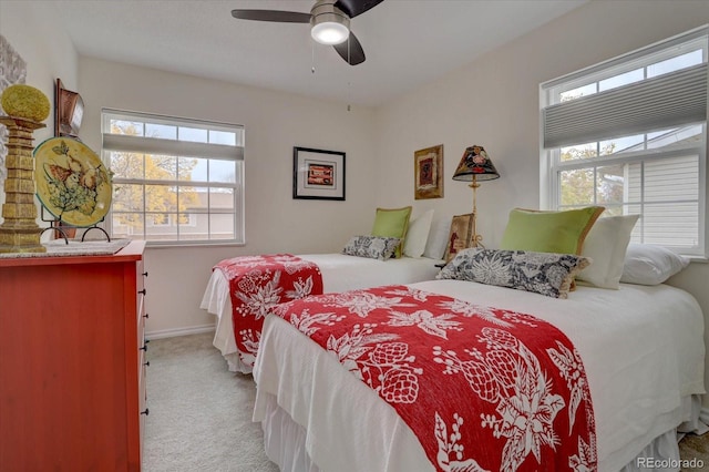 bedroom with light carpet, ceiling fan, and baseboards