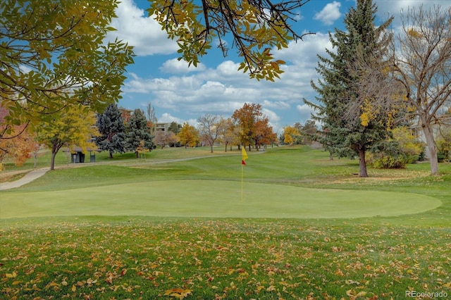 surrounding community featuring a lawn and golf course view