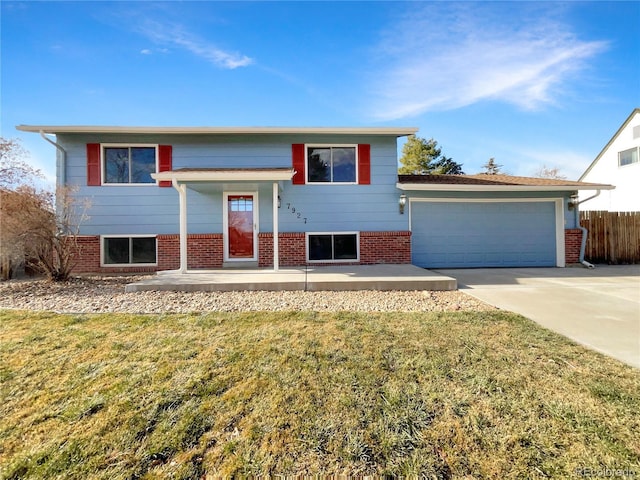 bi-level home with a garage and a front lawn