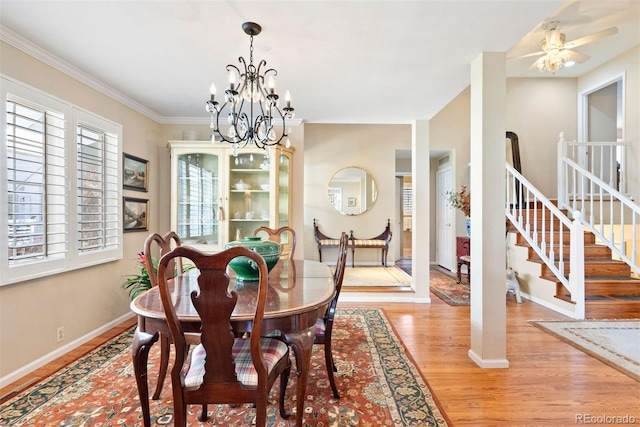 dining room featuring stairway, an inviting chandelier, light wood-style flooring, and baseboards